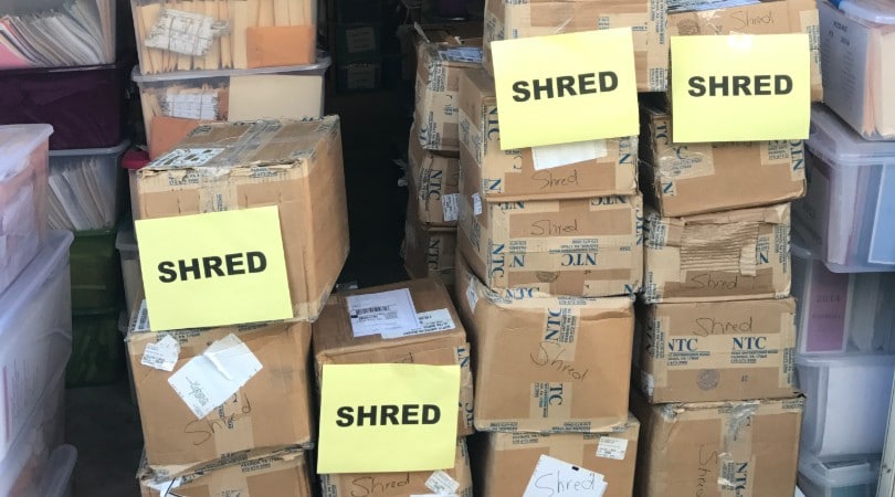 Indianapolis Document Shredding Services image shows a pile of cardboard boxes piled on top of each other. Four of them have a piece of paper on them with the word SHRED.